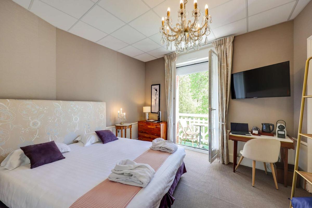 Un ou plusieurs lits dans un hébergement de l'établissement BRIT HOTEL & SPA Le Roc au Chien
