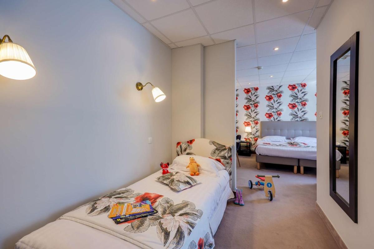 Un ou plusieurs lits dans un hébergement de l'établissement BRIT HOTEL & SPA Le Roc au Chien