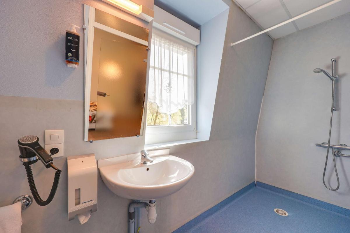 Salle de bains dans l'établissement BRIT HOTEL & SPA Le Roc au Chien