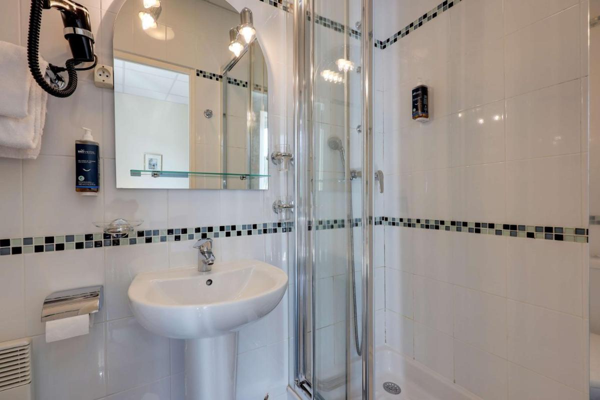 Salle de bains dans l'établissement BRIT HOTEL & SPA Le Roc au Chien