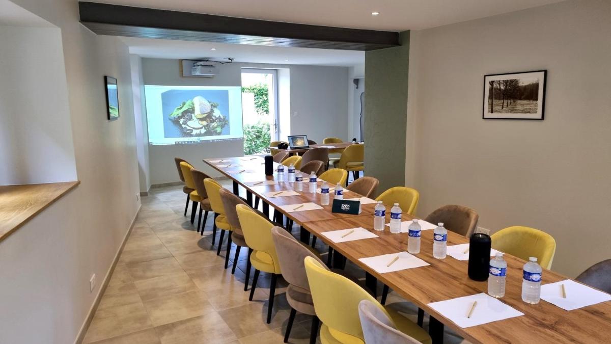 une salle de conférence avec une longue table et des chaises dans l'établissement Logis Hotel Archambeau, à Thonac 105 autres photos