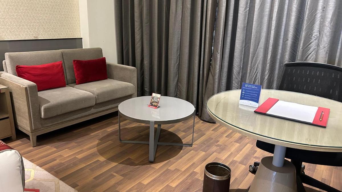 a living room with a couch and a table at Ramada Plaza by Wyndham Lucknow in Lucknow