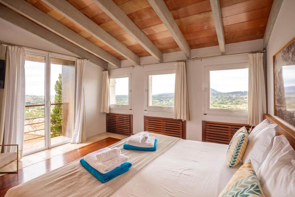 Un dormitorio con una cama con dos pantuflas encima. en Can Cota Boutique - Turismo de interior, en Selva