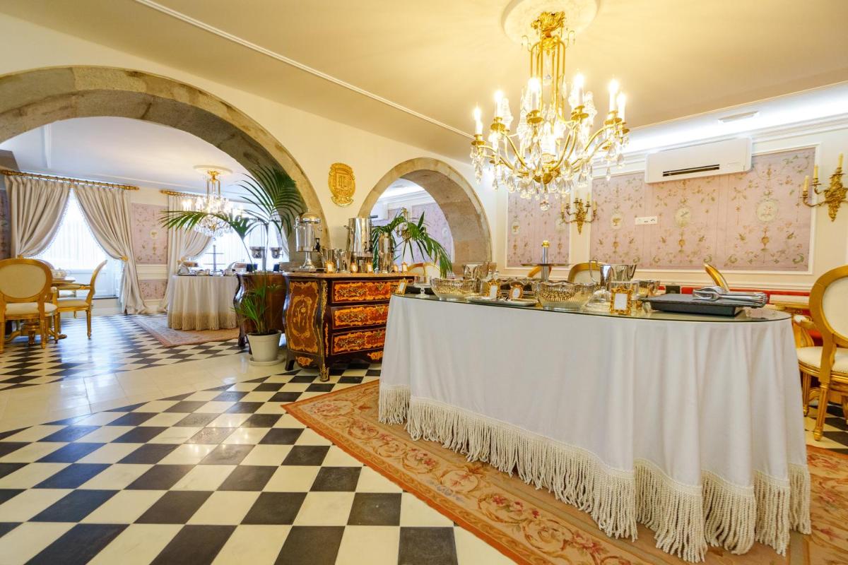 uma sala com uma mesa em uma sala com piso xadrez em Boutique Hotel Teatro em Angra do Heroísmo