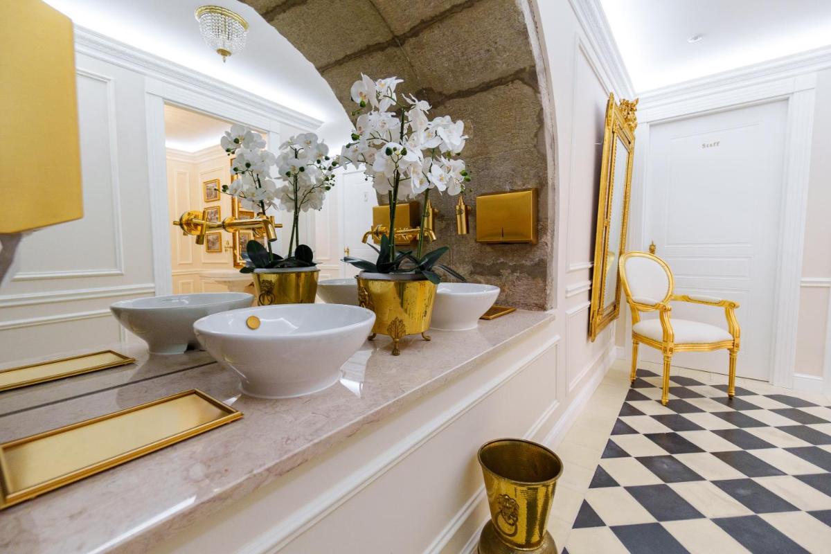 um banheiro com três pias e piso xadrez em Boutique Hotel Teatro em Angra do Heroísmo