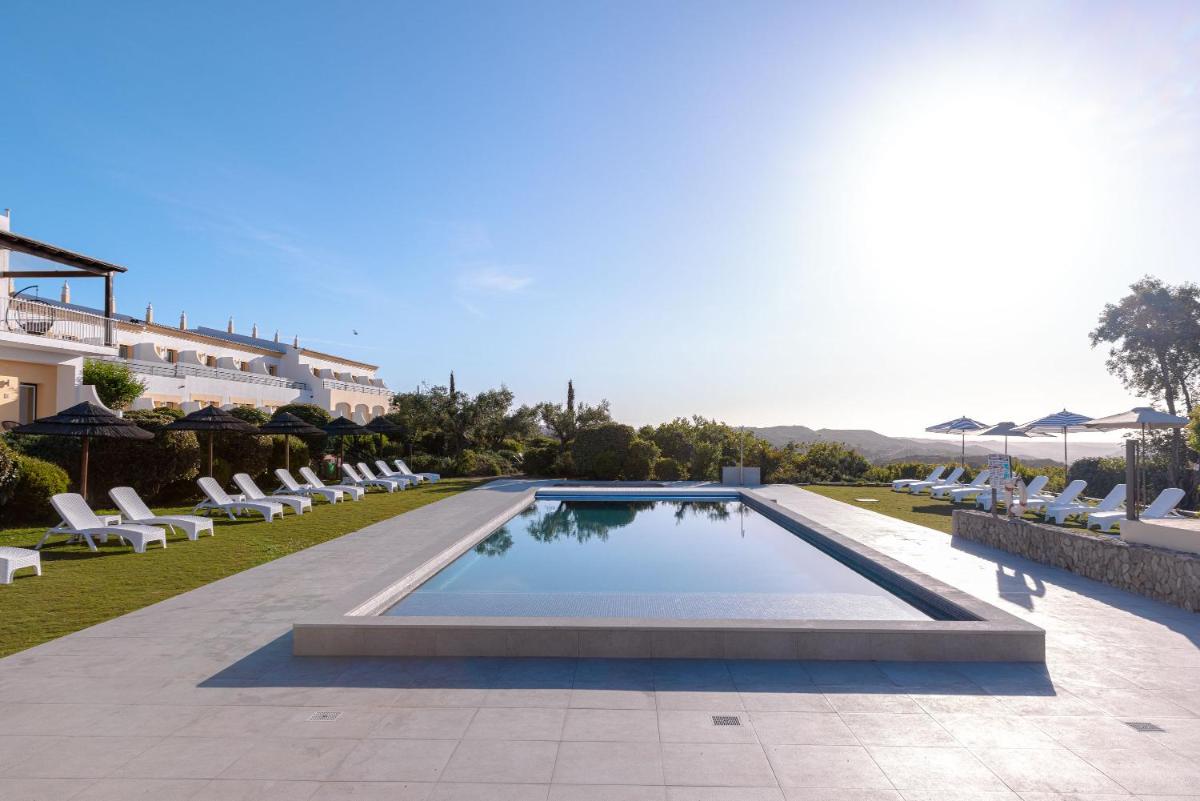 uma piscina com espreguiçadeiras e um resort em Hotel Rural Quinta do Marco - Nature & Dining em Tavira