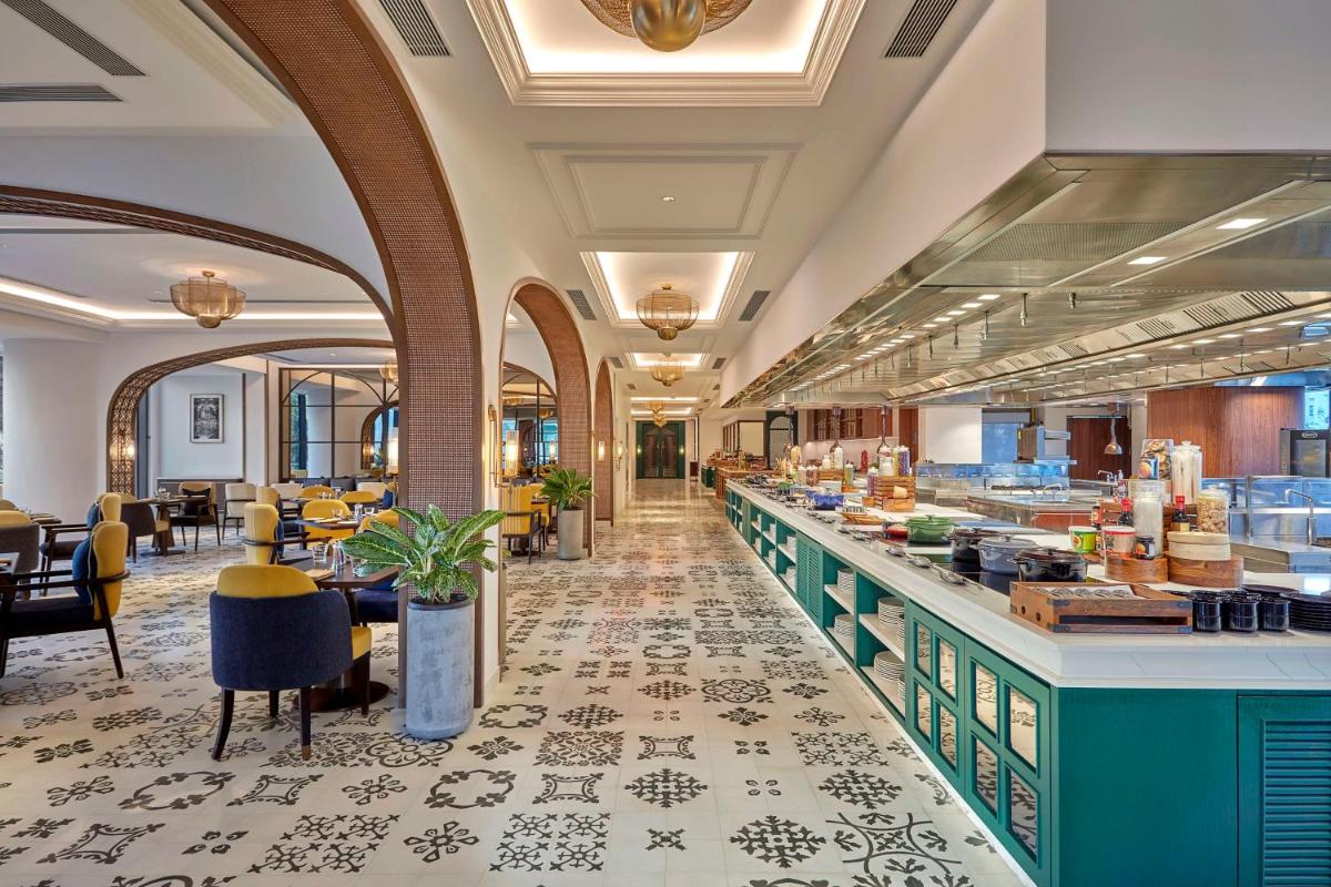 a restaurant with a buffet line with tables and chairs at Doubletree By Hilton Bengaluru Whitefield in Bengaluru a restaurant with a buffet line with tables and chairs at Doubletree By Hilton Bengaluru Whitefield in Bengaluru