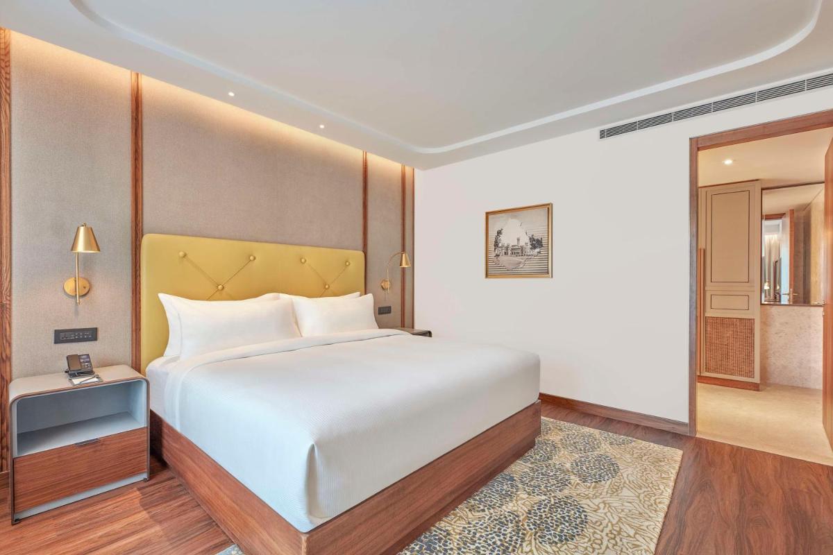 a bedroom with a large white bed and a table at Doubletree By Hilton Bengaluru Whitefield in Bengaluru