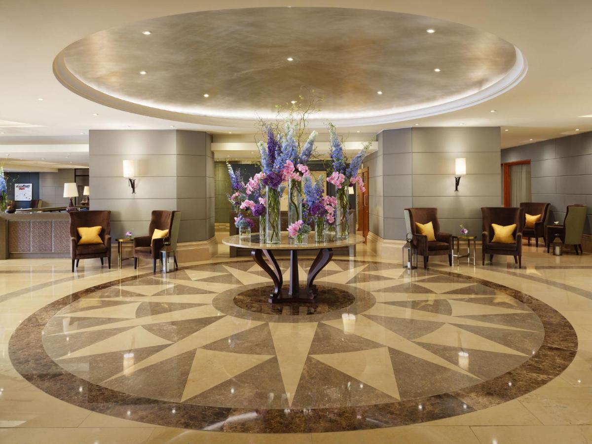um lobby com um grande vaso de flores sobre uma mesa em Corinthia Lisbon em Lisboa
