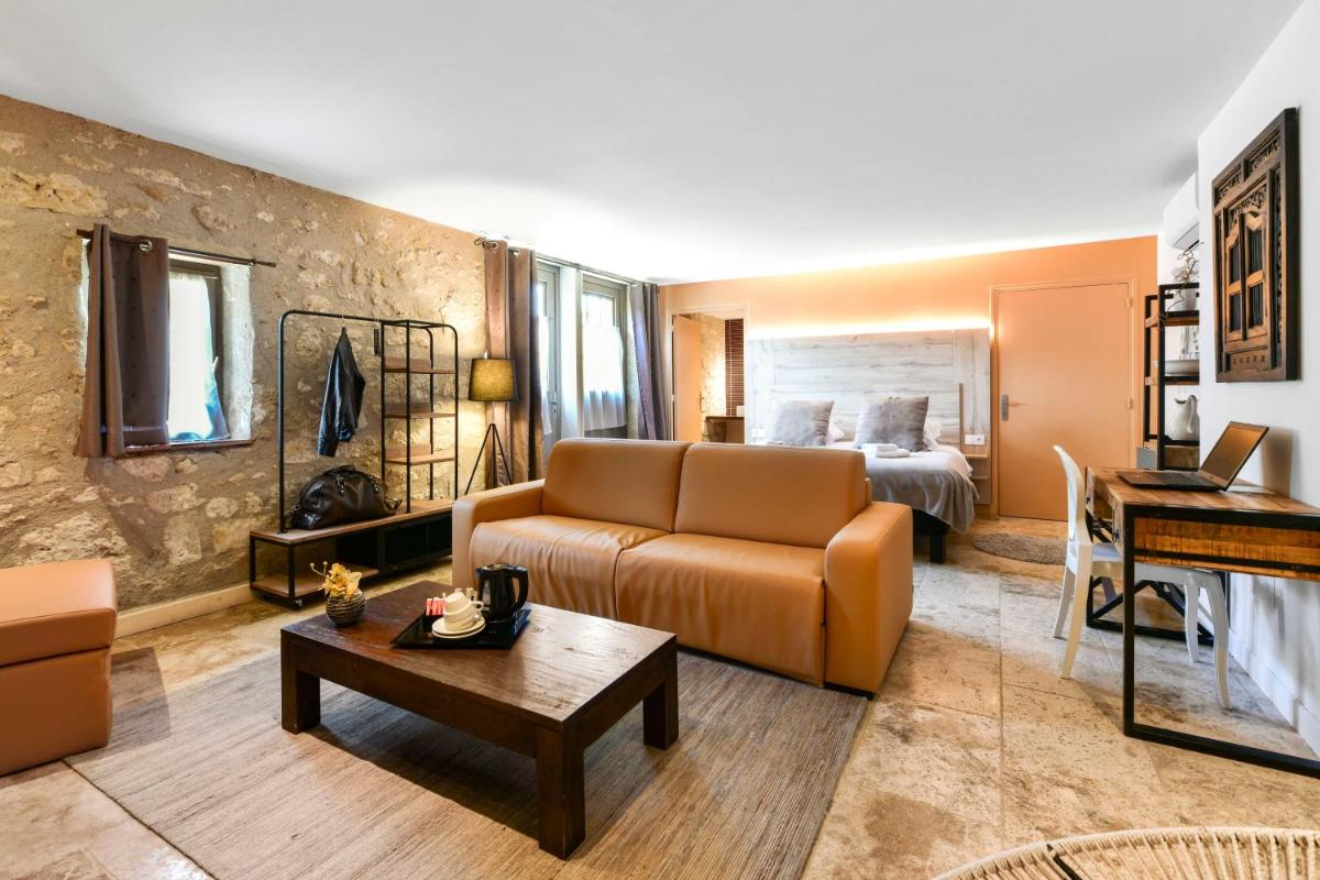 un salon avec un canapé et un lit dans l'établissement Logis L'Auberge de Larressingle, à Larressingle