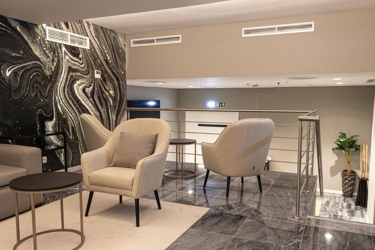 uma sala de espera com cadeiras e uma mesa em MASA Hotel & Spa Campo Grande Collection em Lisboa