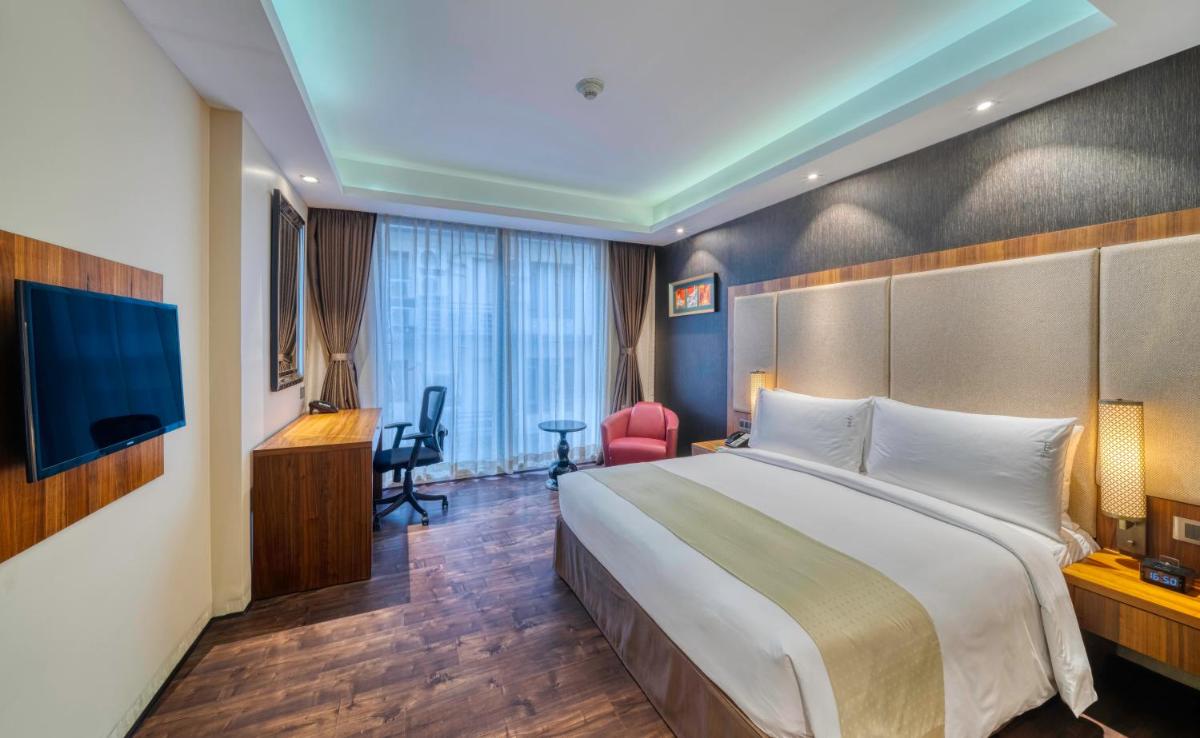 a hotel room with a large bed and a television at Holiday Inn Kolkata Airport by IHG in Kolkata