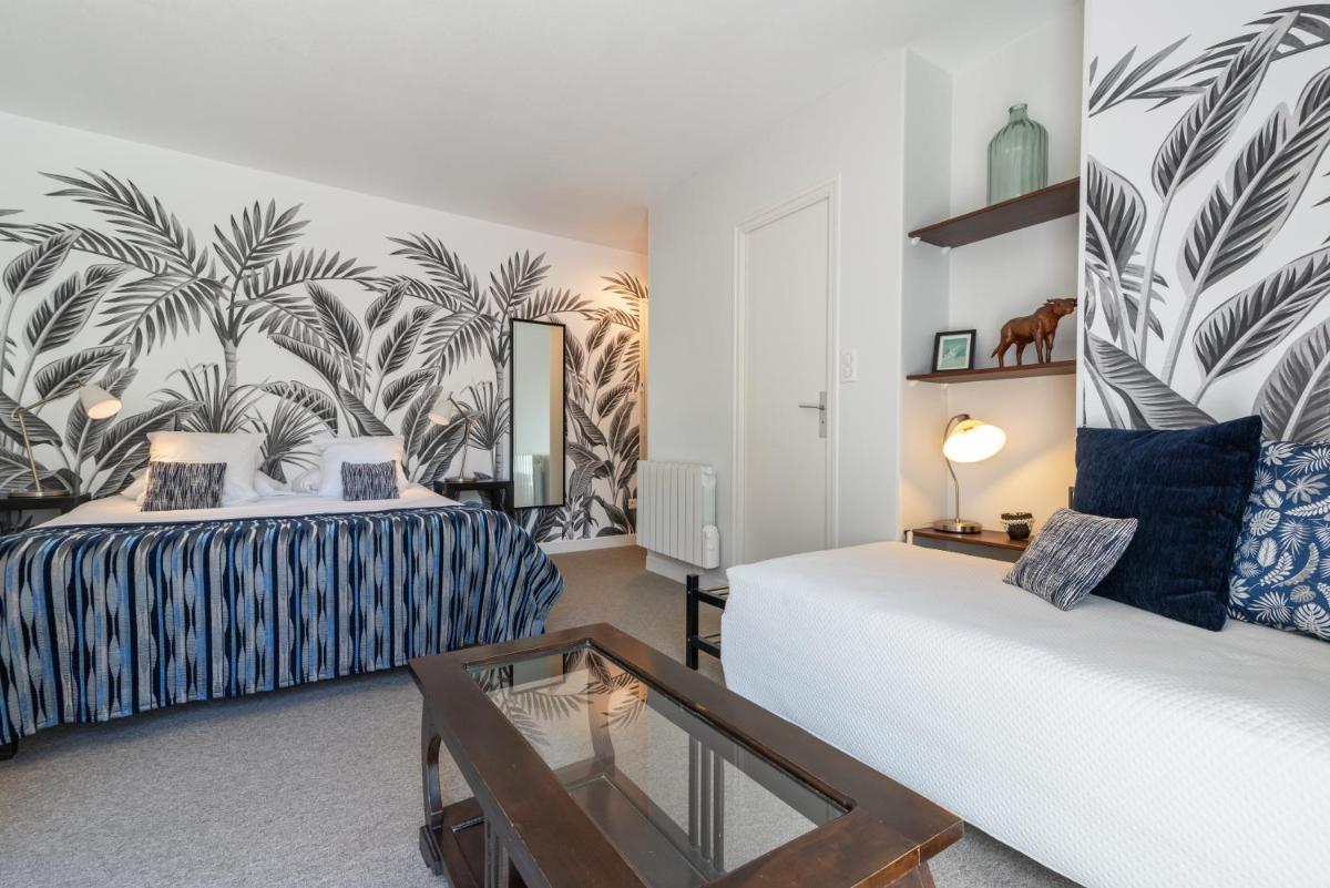 une chambre d'hôtel avec deux lits et un miroir dans l'établissement Carnac Lodge Hotel & Spa, à Plouharnel 78 autres photos