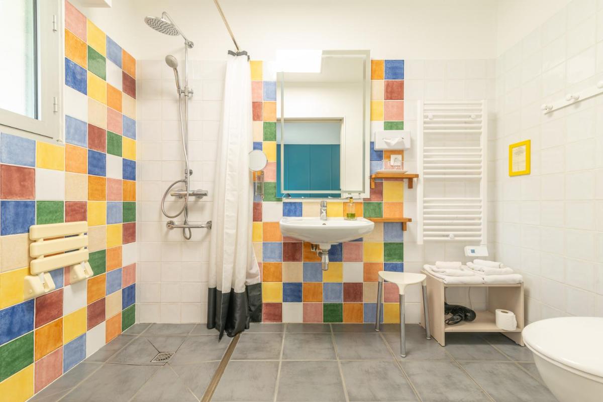 La salle de bains est pourvue d'un lavabo et d'une douche. dans l'établissement Carnac Lodge Hotel & Spa, à Plouharnel