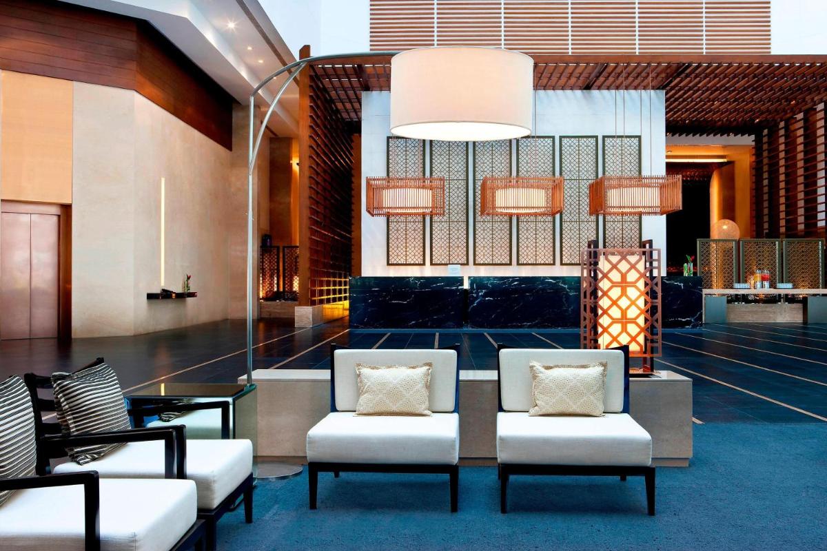a lobby with two chairs and a table at The Westin Hyderabad Mindspace in Hyderabad