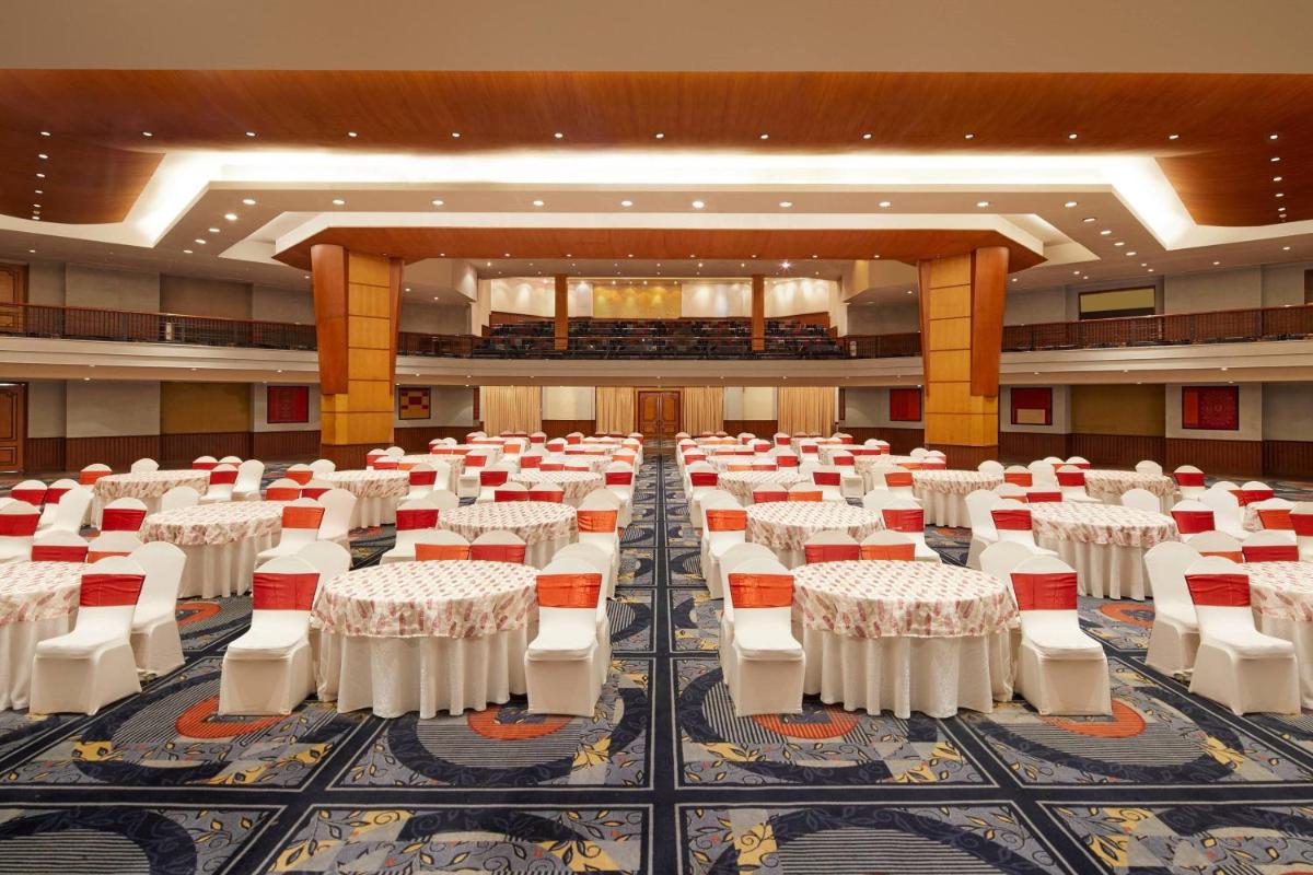 a large banquet hall with white tables and chairs at Hyderabad Marriott Hotel & Convention Centre in Hyderabad