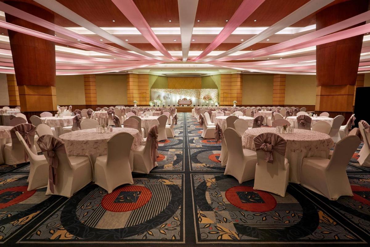 a banquet hall with white tables and chairs at Hyderabad Marriott Hotel & Convention Centre in Hyderabad