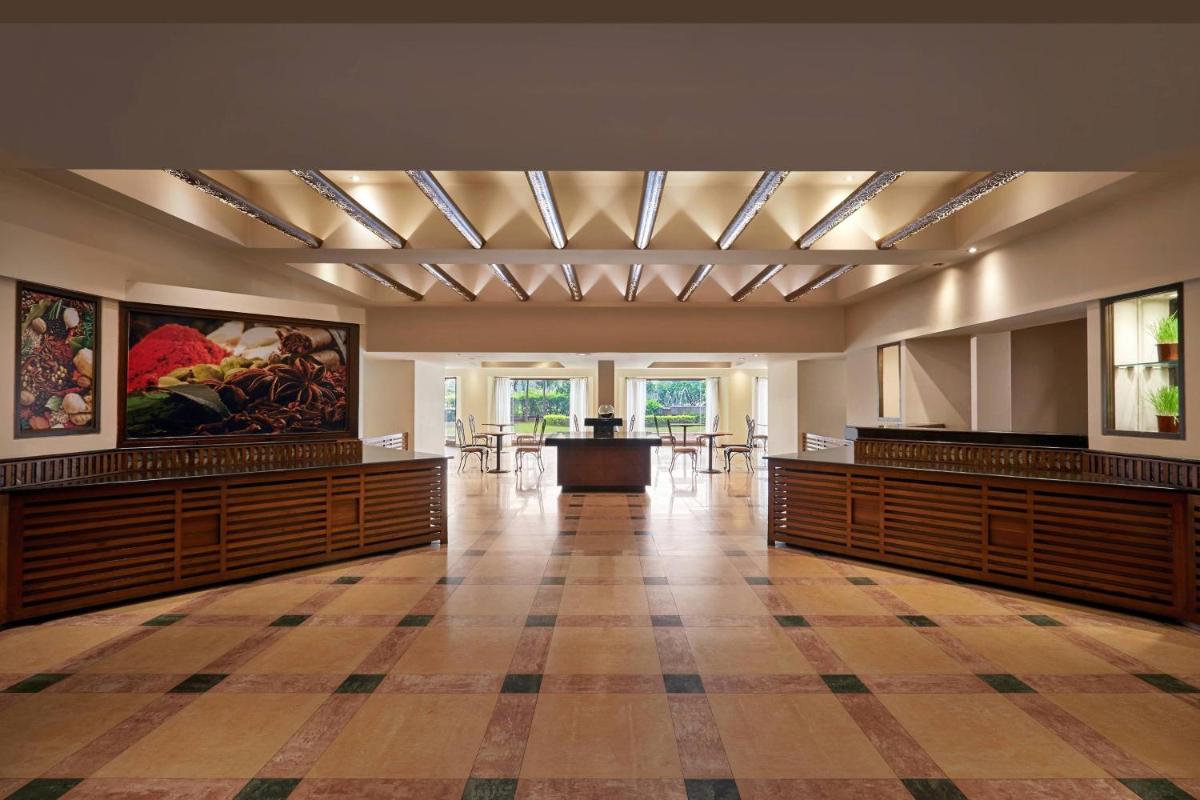 a large room with wooden benches and a table at Hyderabad Marriott Hotel & Convention Centre in Hyderabad
