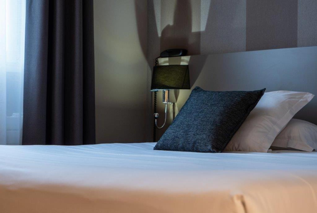 Un ou plusieurs lits dans un hébergement de l'établissement Brit Hotel Le Galion & Spa
