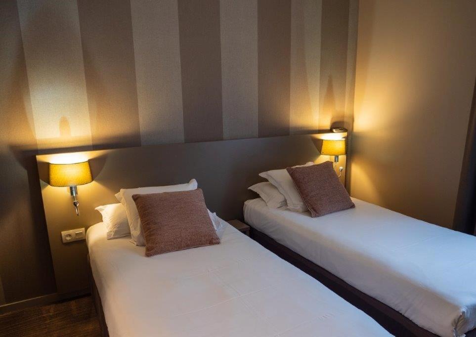 Un ou plusieurs lits dans un hébergement de l'établissement Brit Hotel Le Galion & Spa
