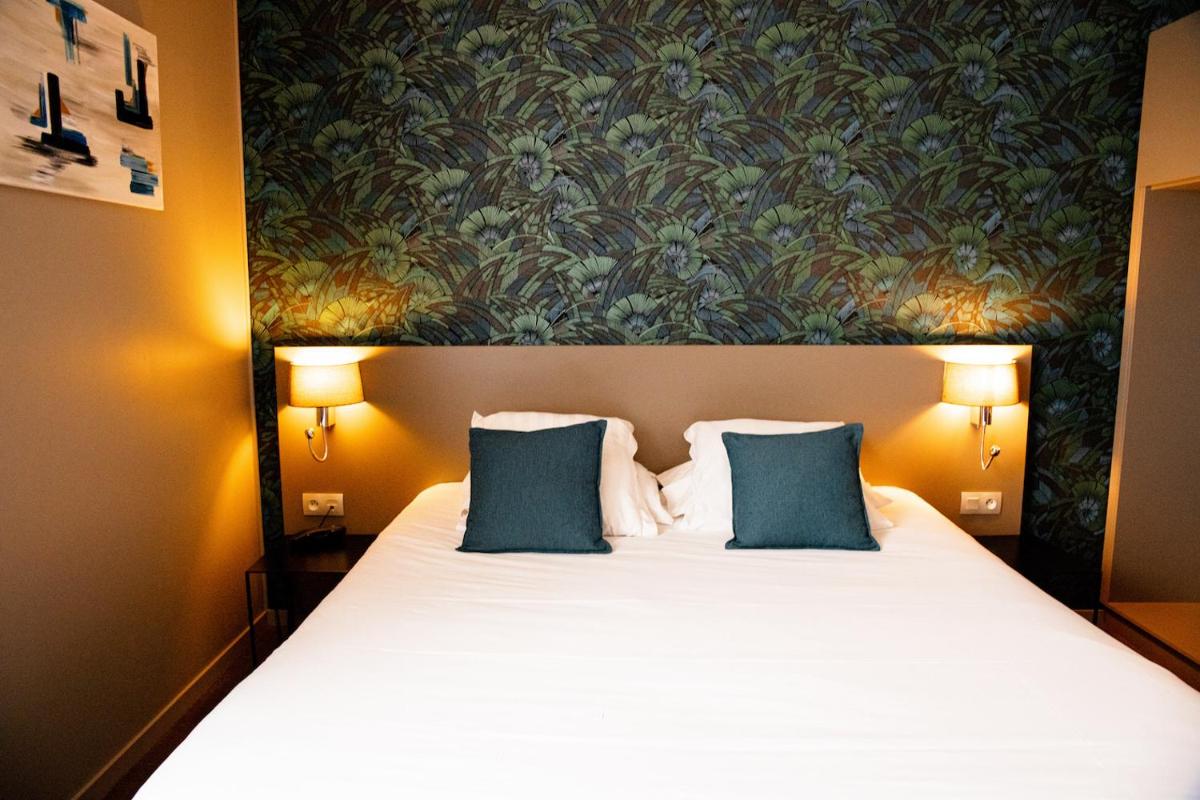 Un ou plusieurs lits dans un hébergement de l'établissement Brit Hotel Le Galion & Spa