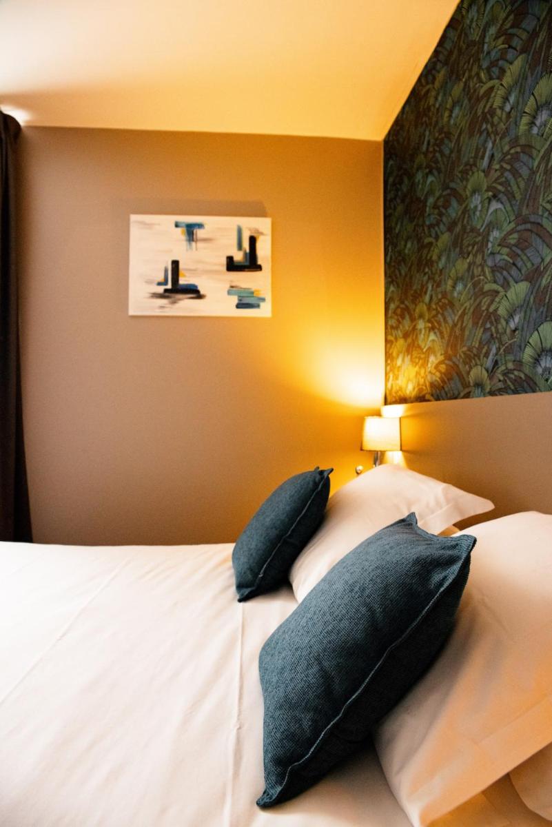 Un ou plusieurs lits dans un hébergement de l'établissement Brit Hotel Le Galion & Spa