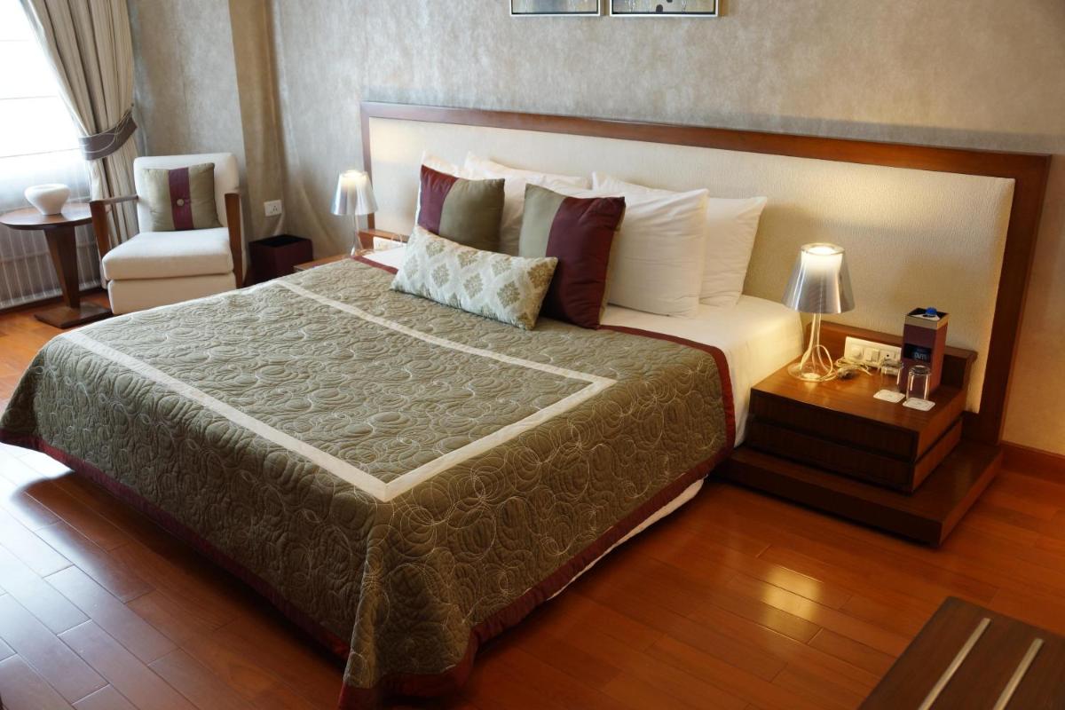 a bedroom with a large bed in a hotel room at Jaypee Vasant Continental in New Delhi