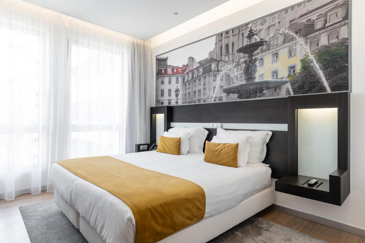 um quarto com uma cama grande e um grande quadro na parede em Jupiter Lisboa Hotel - Rooftop & Spa em Lisboa