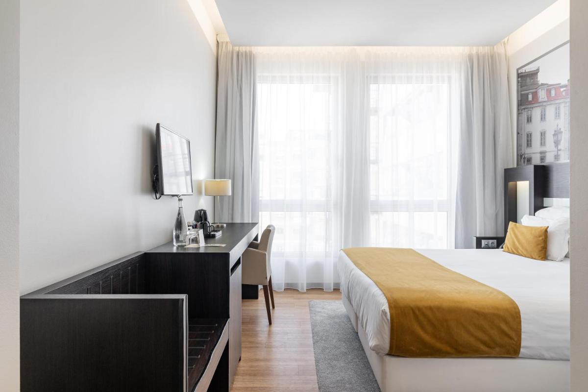 Uma cama ou camas num quarto em Jupiter Lisboa Hotel - Rooftop & Spa