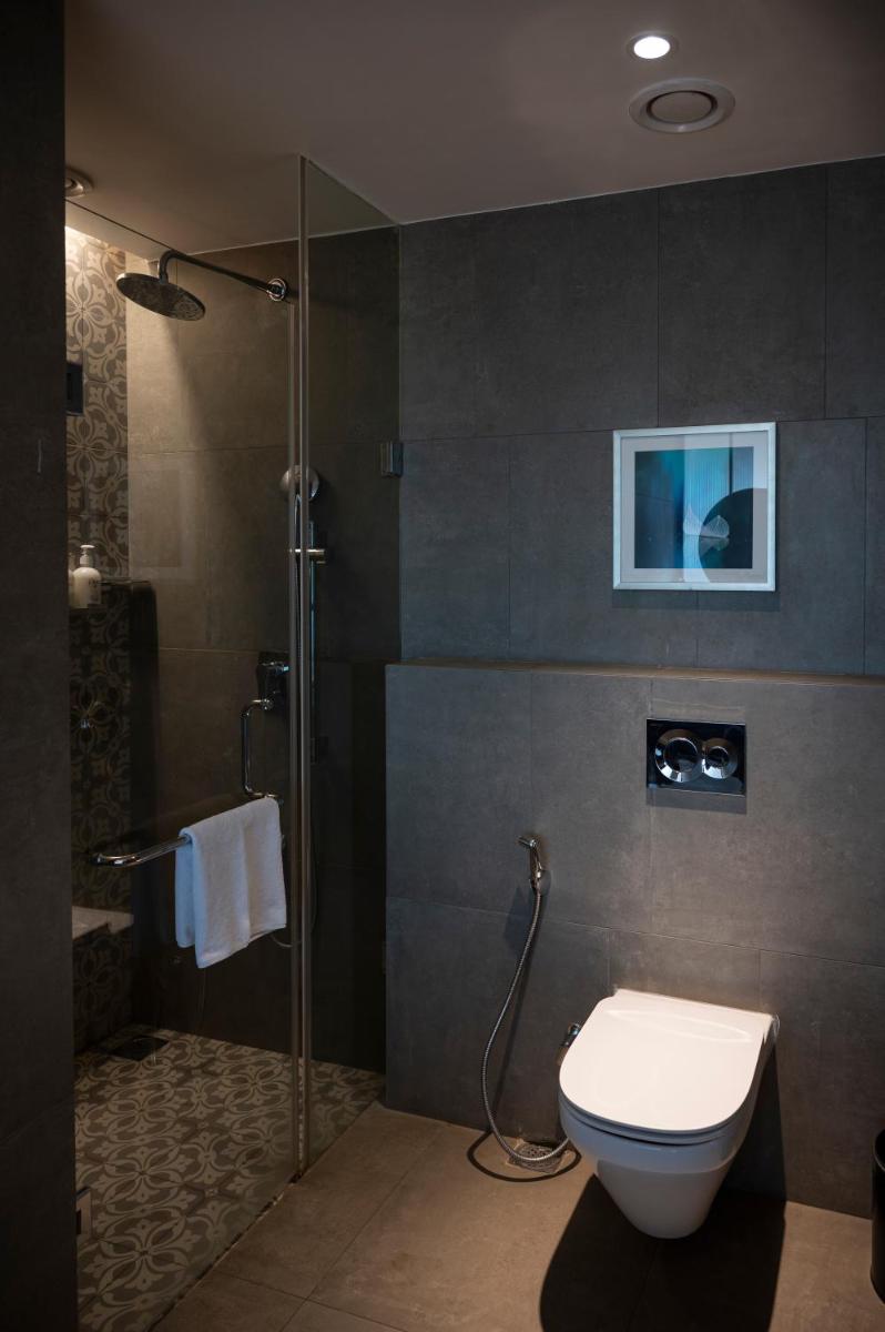 a bathroom with a shower and a toilet and a sink at Holiday Inn Goa Candolim in Candolim a bathroom with a shower and a toilet and a sink at Holiday Inn Goa Candolim in Candolim