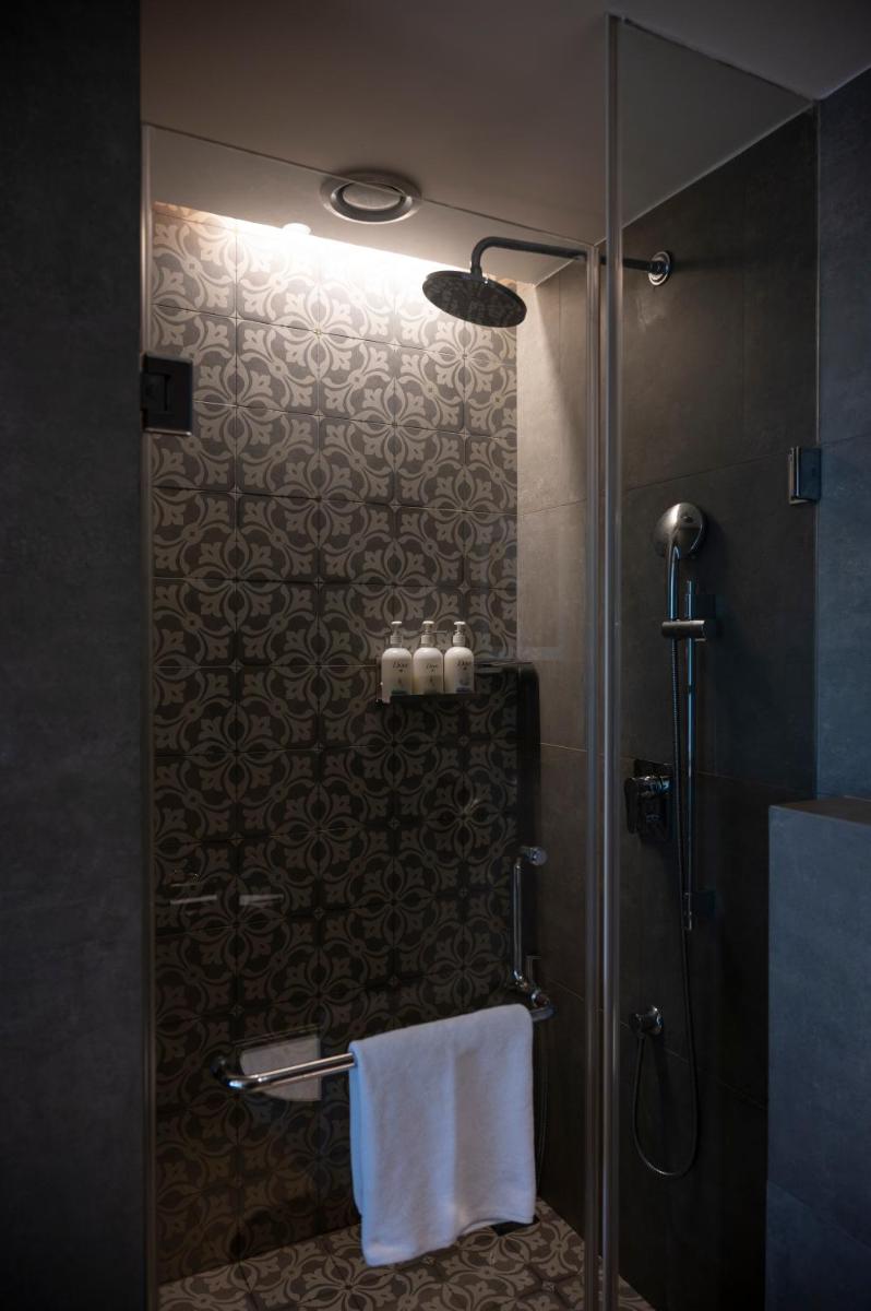 a bathroom with a shower with a glass door at Holiday Inn Goa Candolim in Candolim a bathroom with a shower with a glass door at Holiday Inn Goa Candolim in Candolim