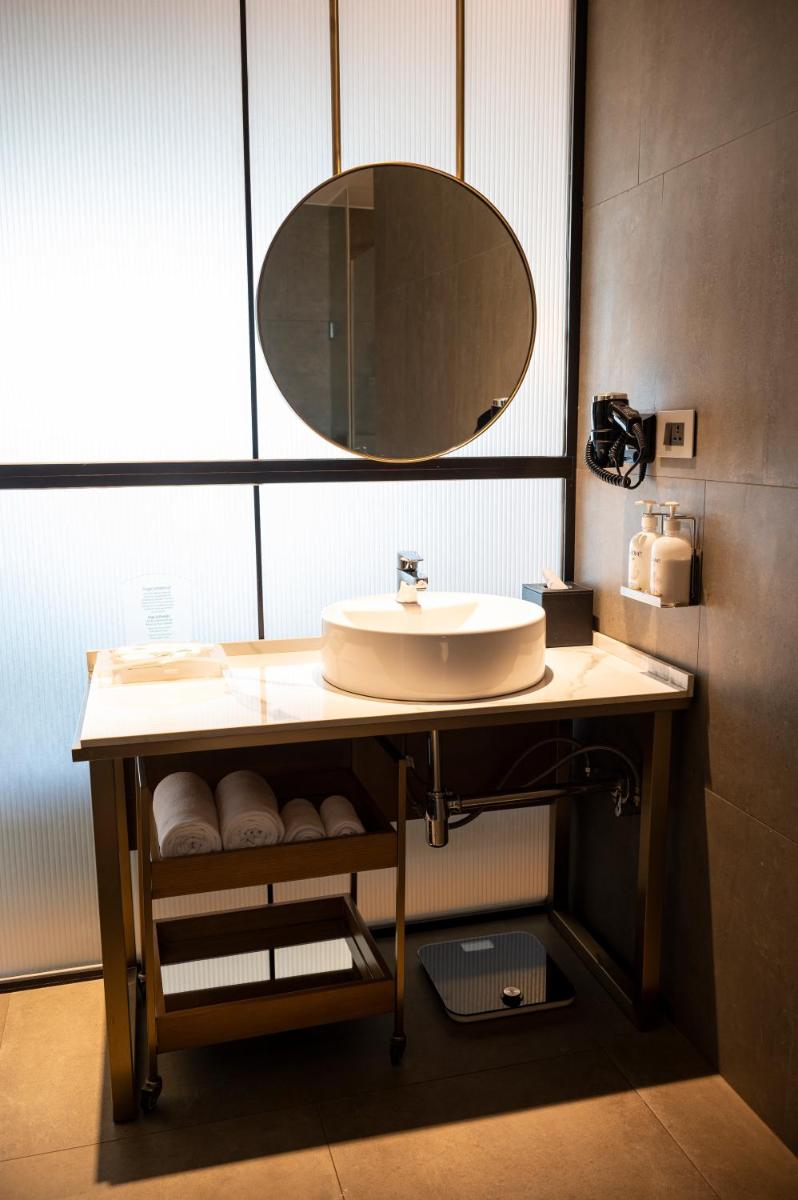 a bathroom with a sink and a mirror at Holiday Inn Goa Candolim in Candolim a bathroom with a sink and a mirror at Holiday Inn Goa Candolim in Candolim