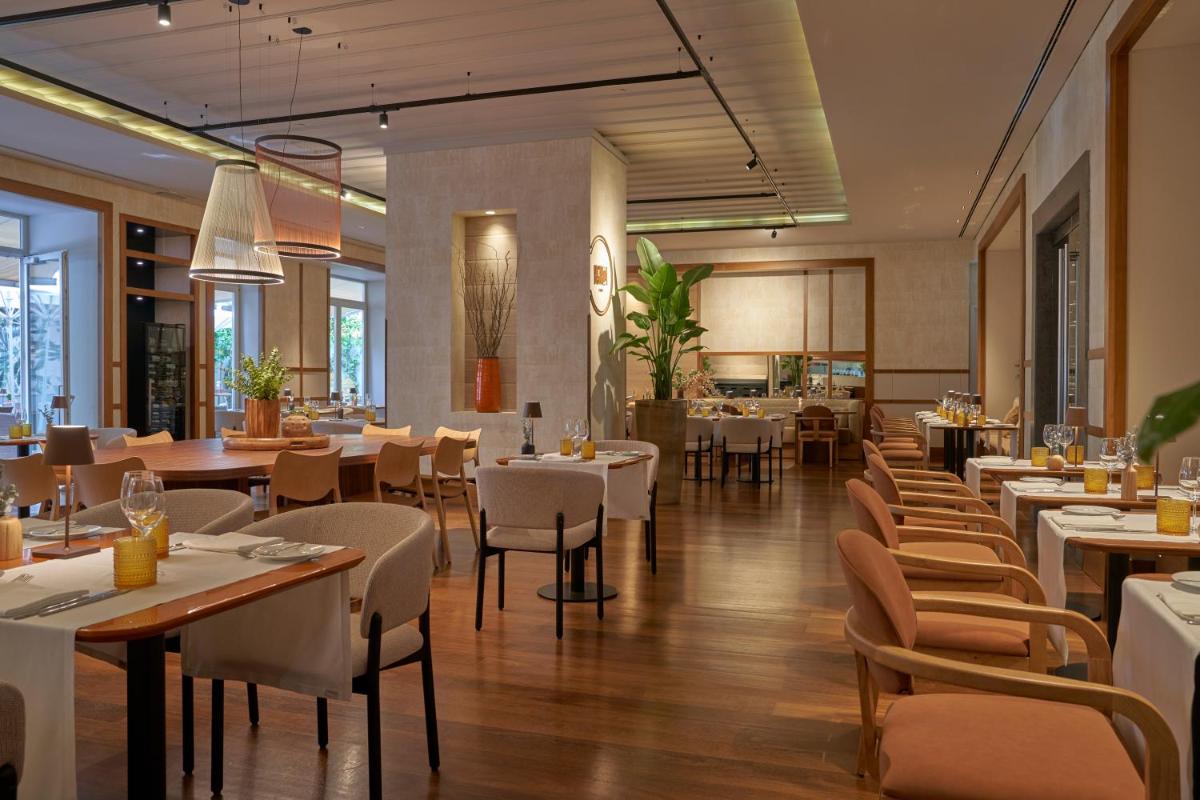 um restaurante com mesas e cadeiras em uma sala em PortoBay Liberdade em Lisboa