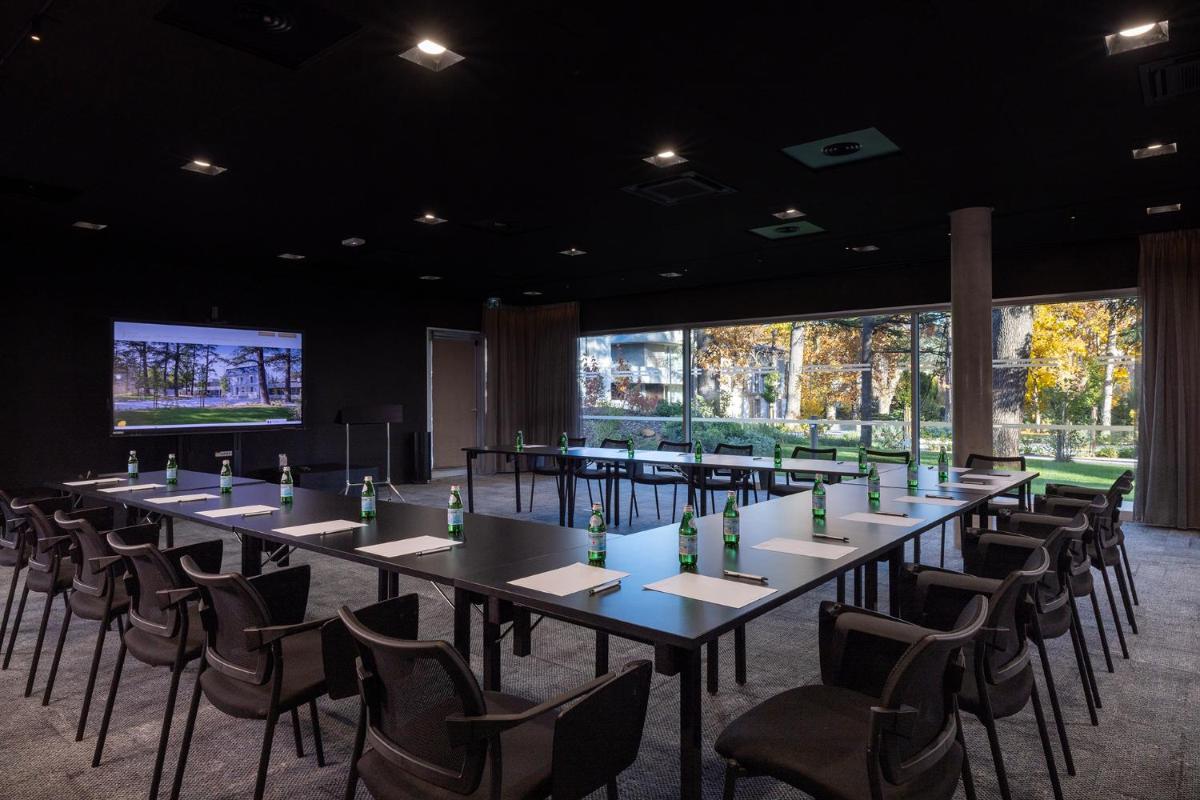 une rangée de tables et de chaises dans une pièce avec de grandes fenêtres dans l'établissement Hôtel Spa Restaurant Villa Castellane, à Gréoux-les-Bains 66 autres photos