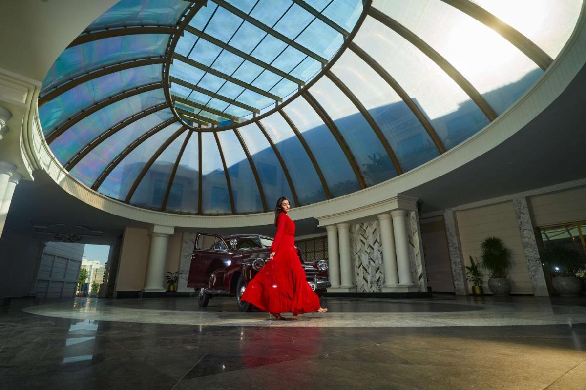 a woman in a red dress walking in a building at Radisson Blu Hotel & Suites GRT Chennai in Chennai