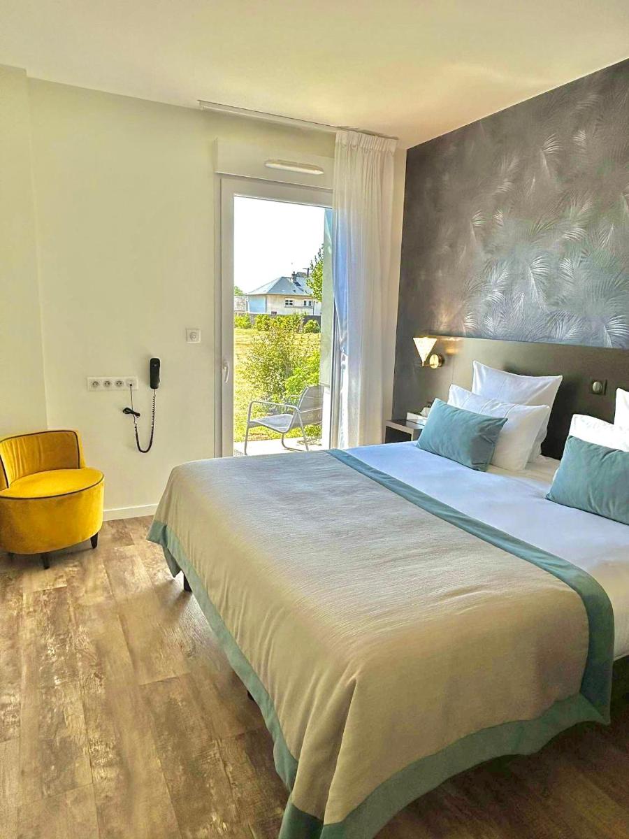 une chambre avec un grand lit et une fenêtre dans l'établissement Brame de Sologne, à Muides-sur-Loire