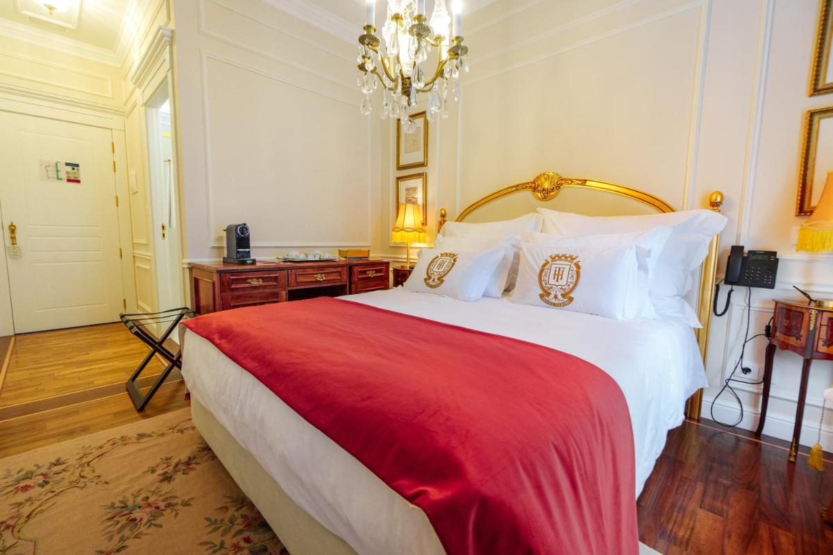 um quarto com uma cama grande com um cobertor vermelho em Boutique Hotel Teatro em Angra do Heroísmo