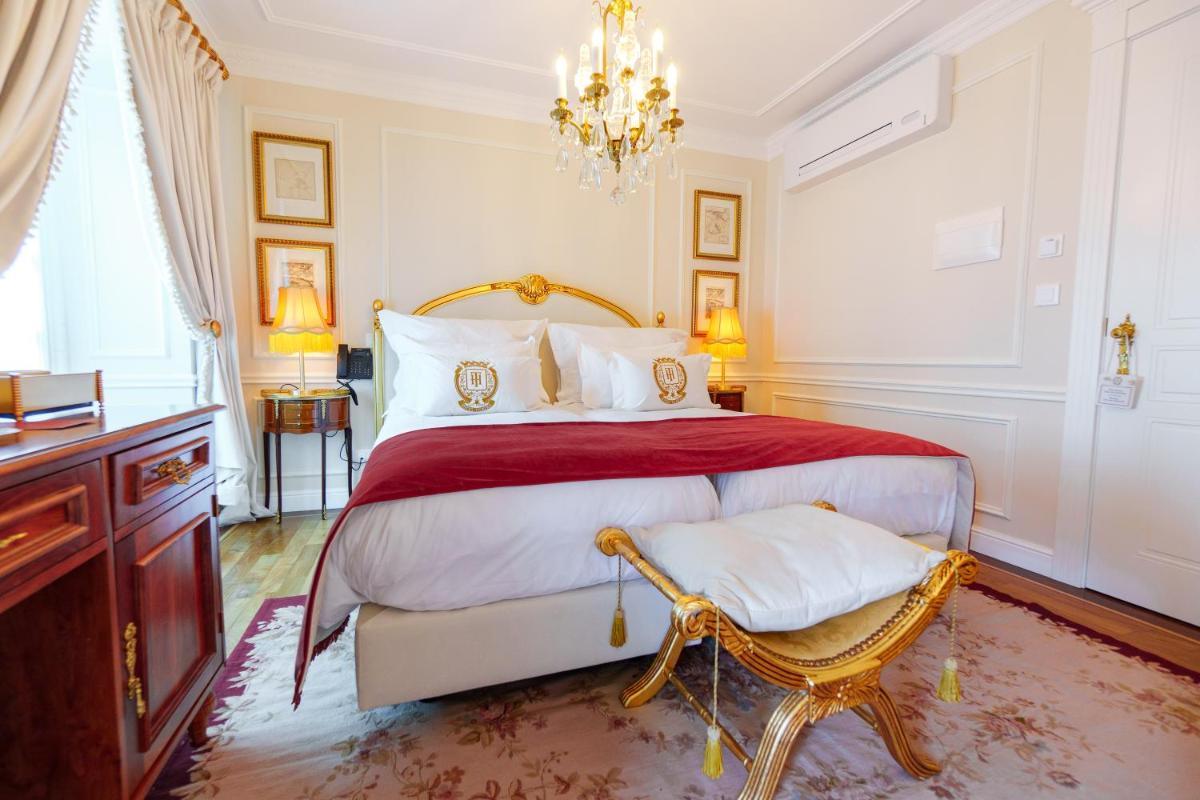 um quarto com uma cama grande e um lustre em Boutique Hotel Teatro em Angra do Heroísmo mais 77 fotografias