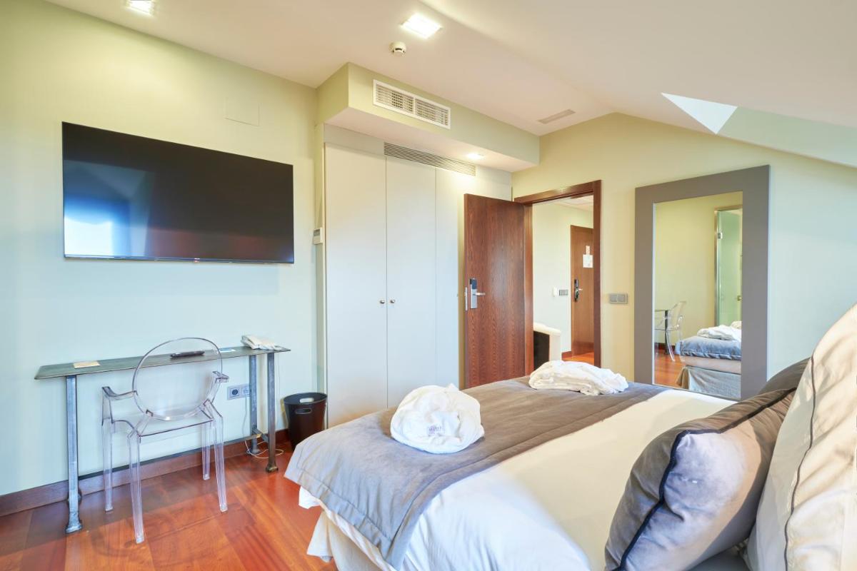 Una televisión o centro de entretenimiento en Hotel AR Isabel de Farnesio