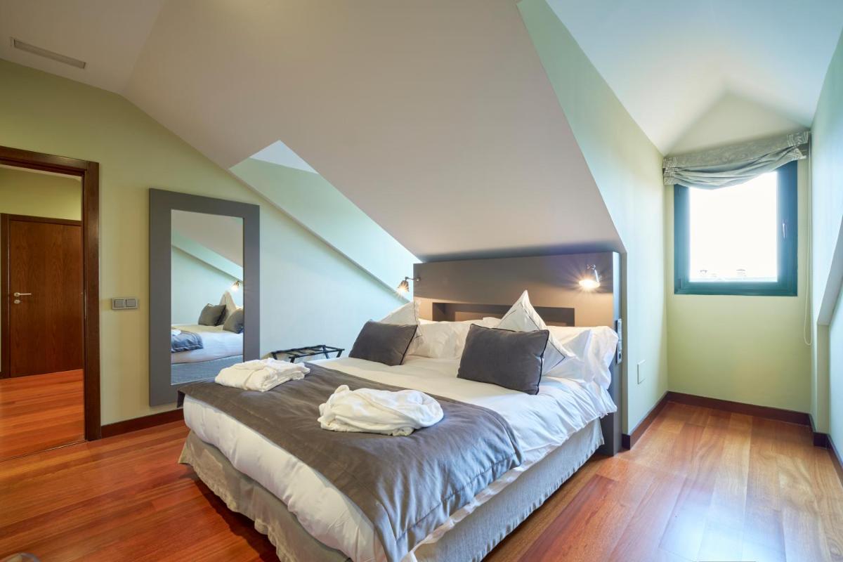 Un dormitorio con una cama grande con un espejo grande. en Hotel AR Isabel de Farnesio, en La Granja de San Ildefonso