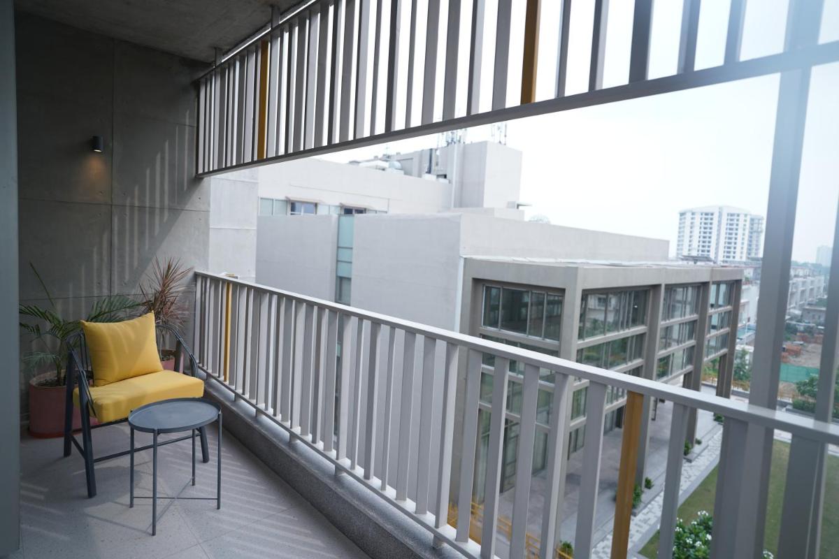 a balcony with a yellow chair and a table at The Centrum in Lucknow
