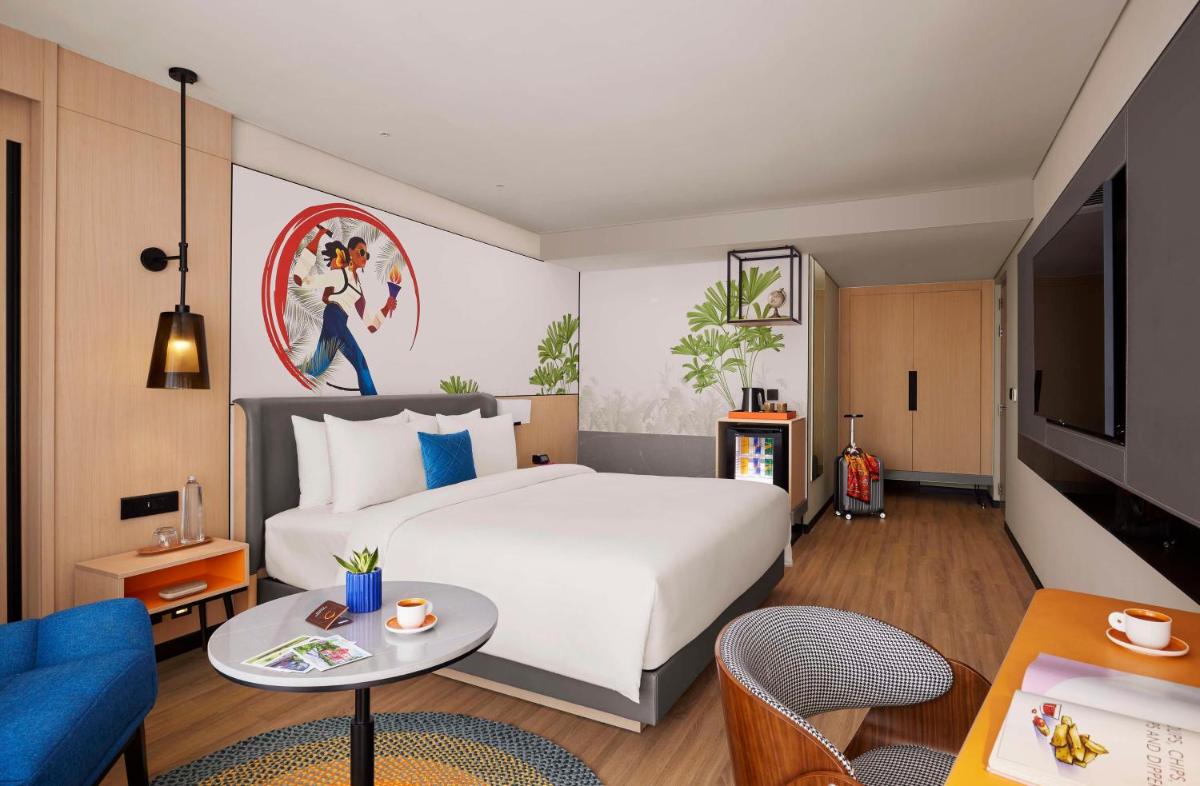 a bedroom with a large white bed and a living room at Hyatt Centric Hebbal Bengaluru in Bengaluru
