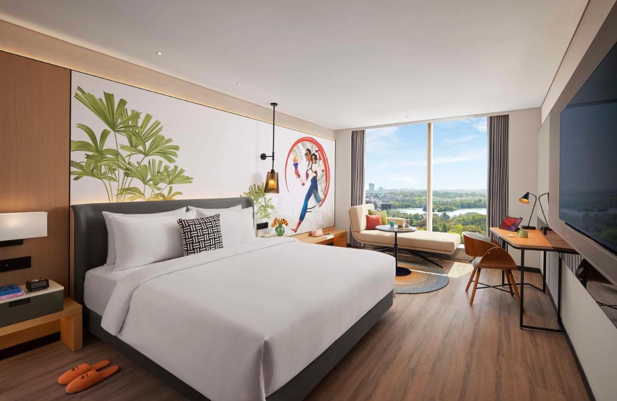 a bedroom with a large white bed and a desk at Hyatt Centric Hebbal Bengaluru in Bengaluru
