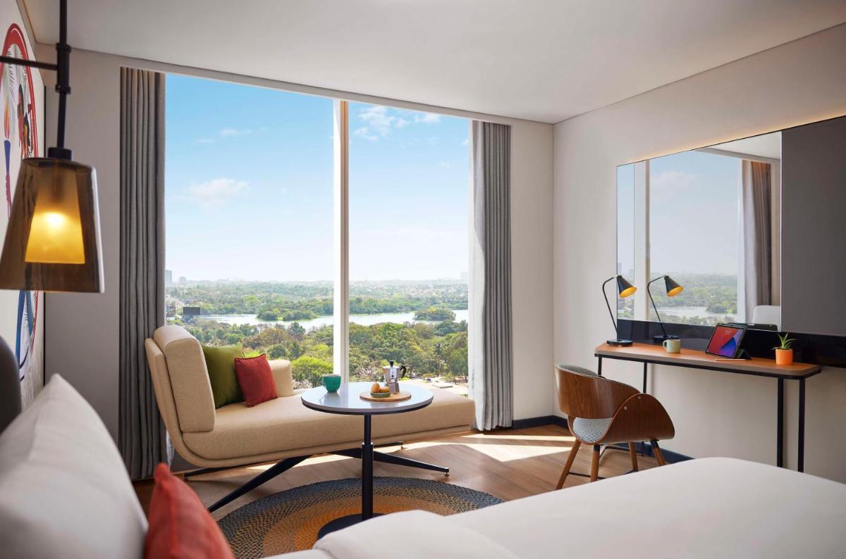 a hotel room with a bed and a large window at Hyatt Centric Hebbal Bengaluru in Bengaluru