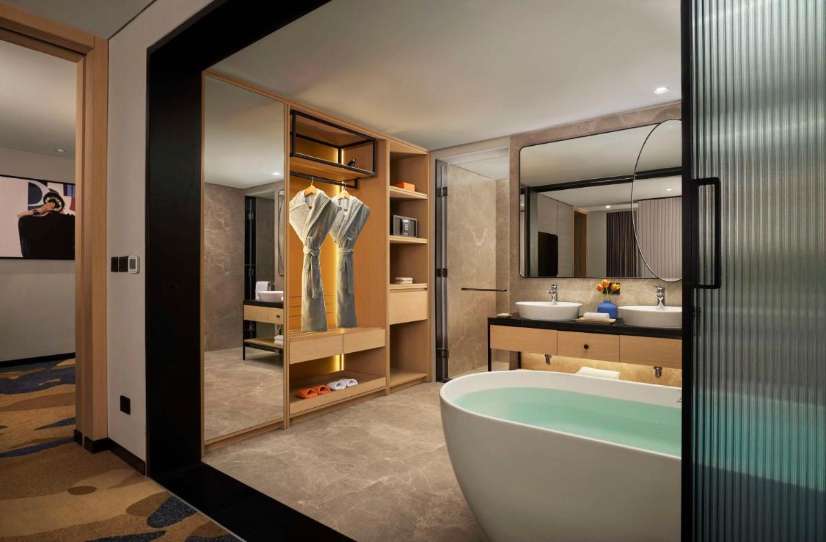 a bathroom with a tub and a sink at Hyatt Centric Hebbal Bengaluru in Bengaluru a bathroom with a tub and a sink at Hyatt Centric Hebbal Bengaluru in Bengaluru