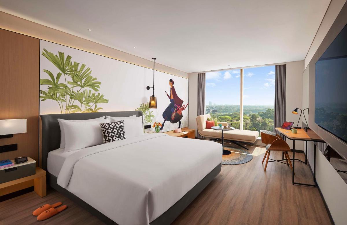 a bedroom with a large white bed and a desk at Hyatt Centric Hebbal Bengaluru in Bengaluru