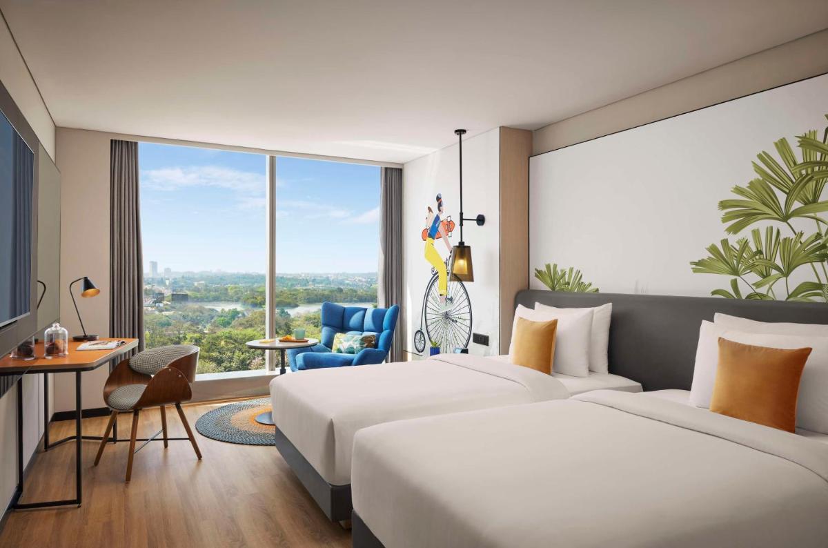 a hotel room with two beds and a large window at Hyatt Centric Hebbal Bengaluru in Bengaluru