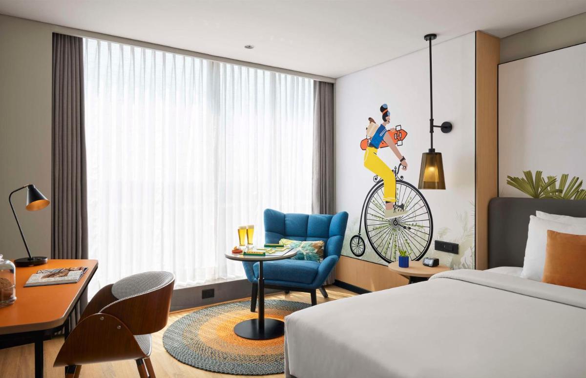 a hotel room with a bed and a desk and a chair at Hyatt Centric Hebbal Bengaluru in Bengaluru
