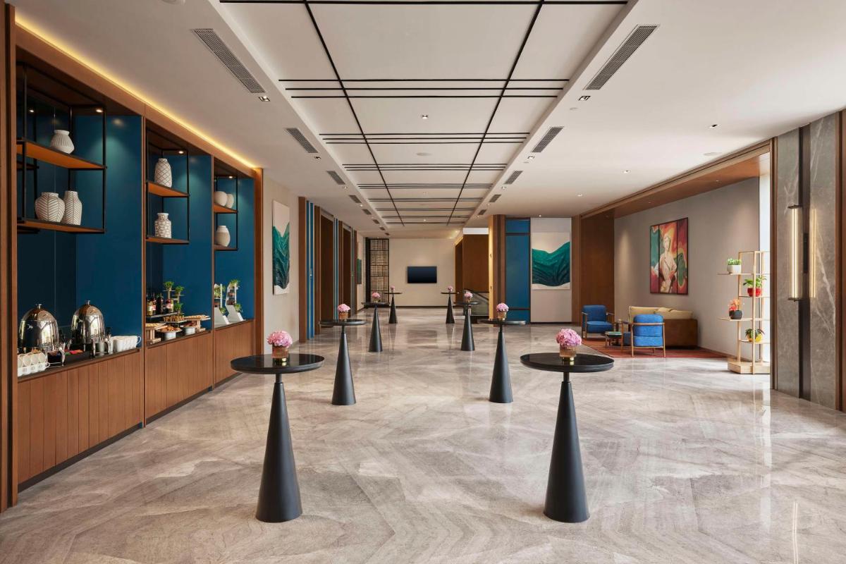 a lobby with tables with flowers on them at Hyatt Centric Hebbal Bengaluru in Bengaluru