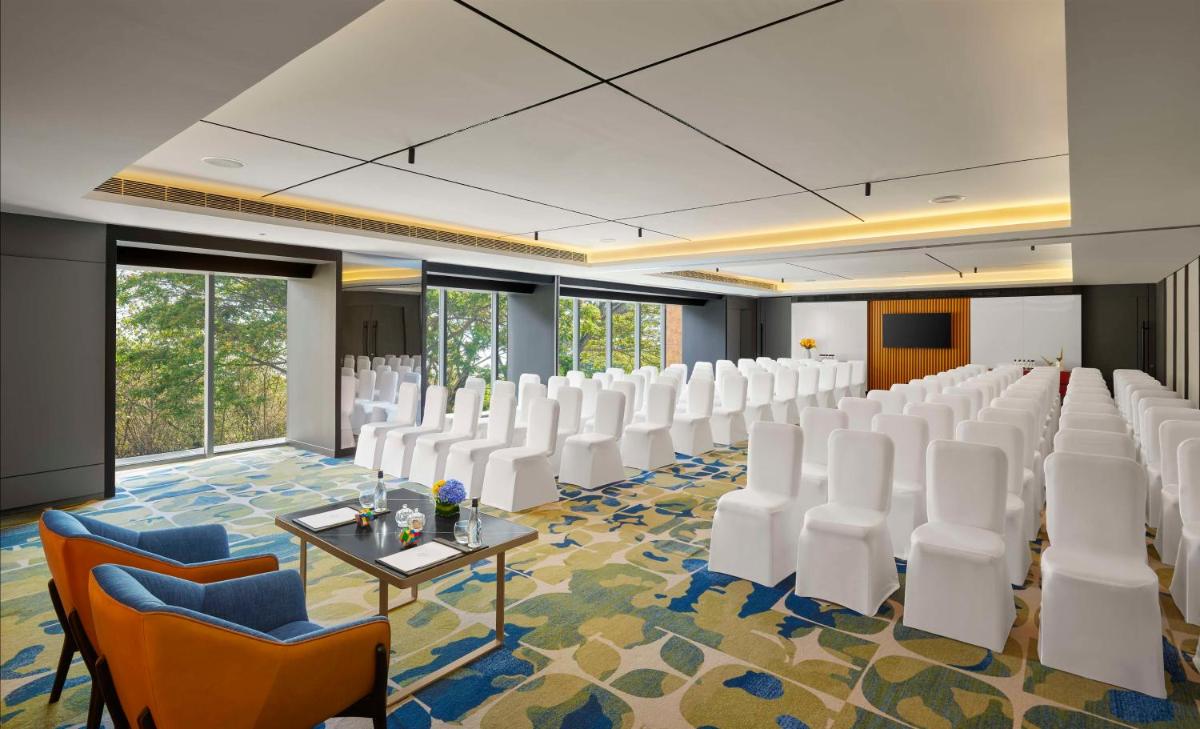 a conference room with white chairs and a table at Hyatt Centric Hebbal Bengaluru in Bengaluru